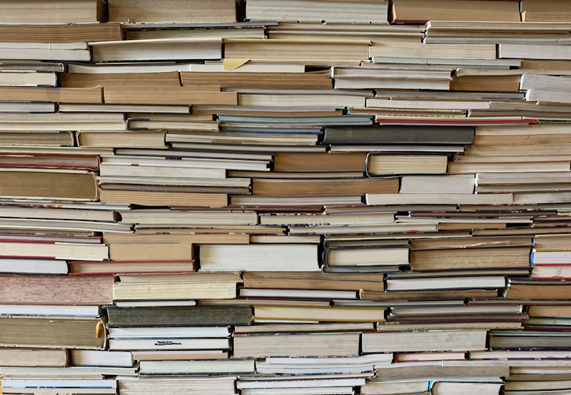 Wall of stacked books seen from the page edges, in warm paper tones