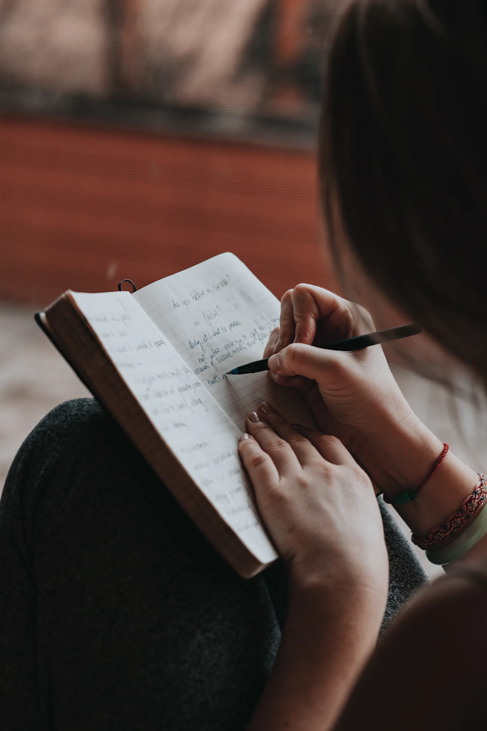 Woman writing reflections by hand in an open journal