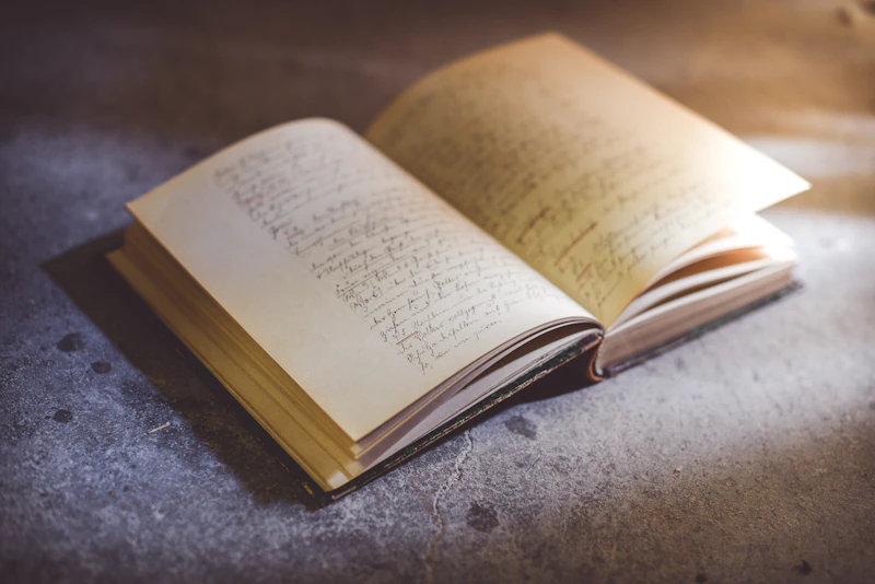Antique book of handwritten notes open in soft warm light
